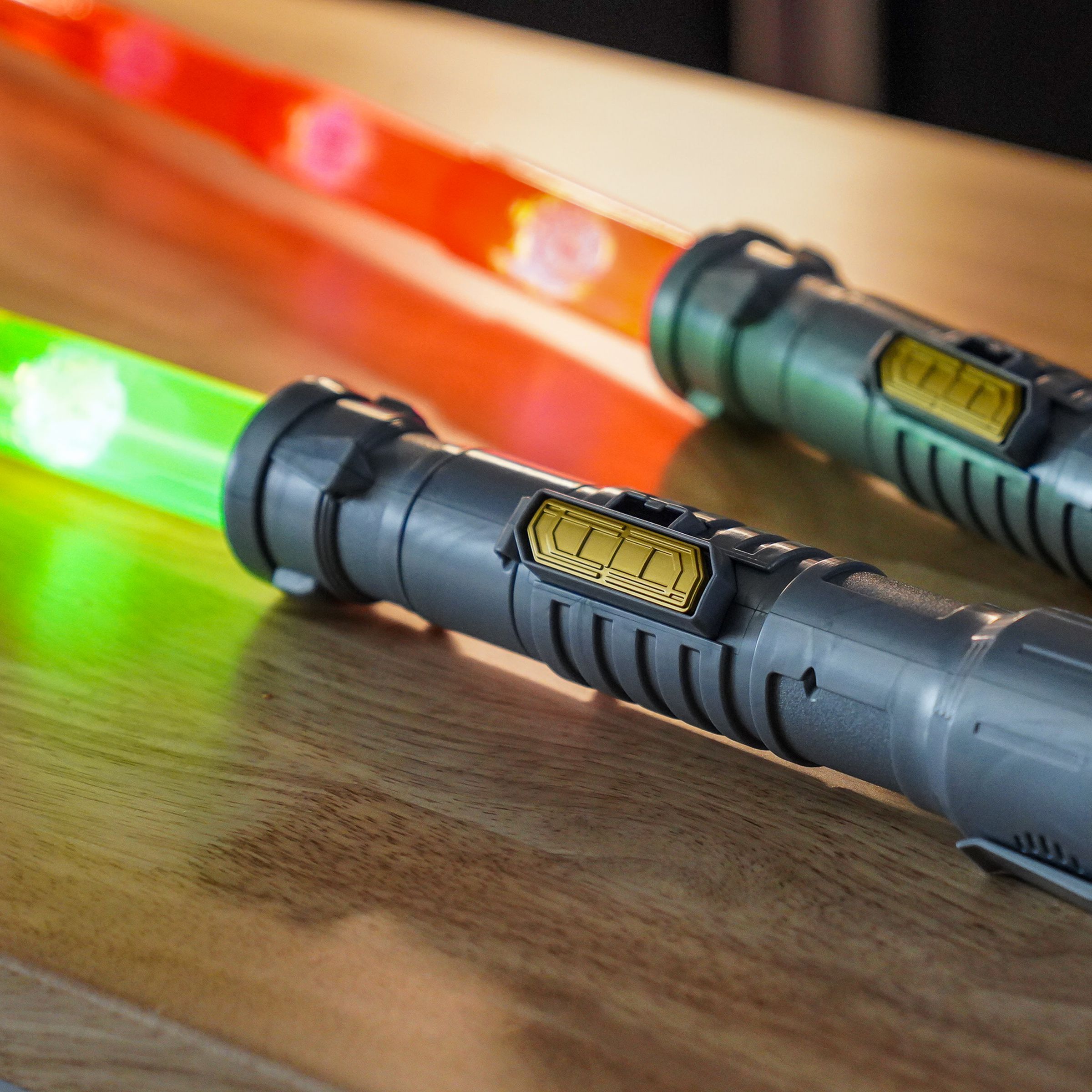 Lightsaber toys in silver, with golden sliding switches on the side, identical save for their red and green blades.